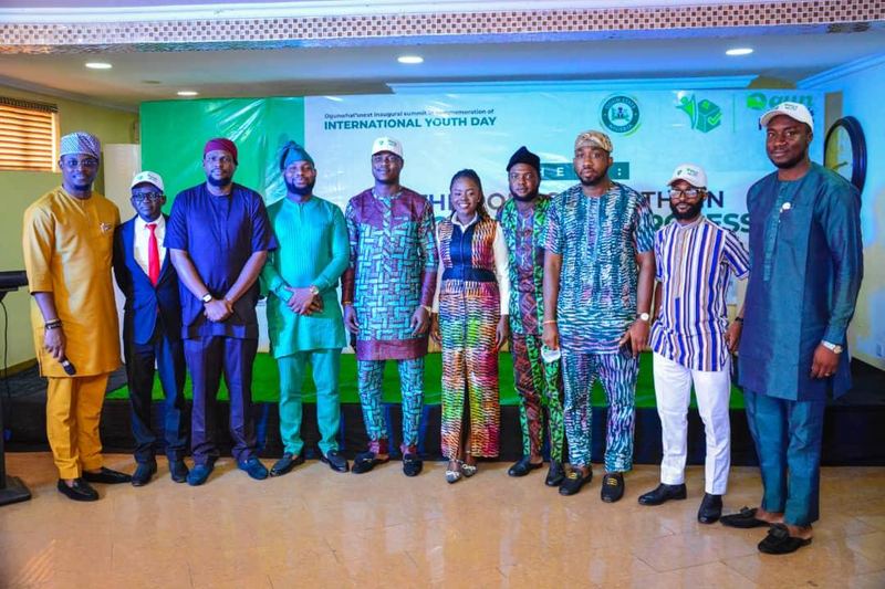 A line of organisers and guests stand in front of the summit backdrop.